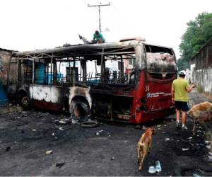 Este fue uno de los autobuses que los manifestantes incendiaron en las violentas protestas, donde cuatro personas murieron y más de 200 resultaron heridas. Foto: AFP