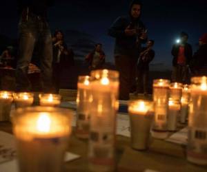 La gente mientras encendía las candelas durante la vigilia en memoria a los inmigrantes fallecidos. Foto: Agencia AFP.