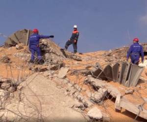 En esta imagen, tomada de un video distribuido por el servicio de prensa del Ministerio de Situaciones de Emergencia de Rusia, efectivos del departamento caminan entre los restos de una explosión en el puerto de Beirut, Líbano, el 6 de agosto de 2020.