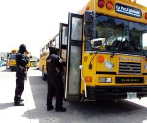 Agentes de la FNAMP mientras realizan una inspección a un bus amarillo estacionado en la Central Única de Comayagua. Foto: Cortesía.