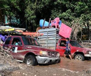 Workers of banana fields come across a flooded road while evacuating the area in El Progreso, Yoro department, Honduras, on November 14, 2020, before the arrival of tropical storm Iota. - Less than two weeks after powerful storm Eta killed more than 200 people across Central America, authorities on Saturday warned that storm Iota is likely to wallop coastal areas of Nicaragua and Honduras on Monday as a major hurricane. (Photo by Orlando SIERRA / AFP)