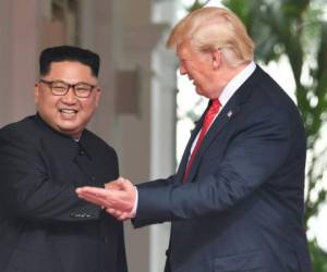 Kim Jong Un y Donald Trump se estrechan la mano.