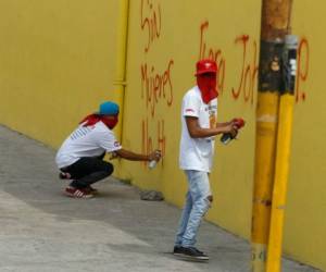 Estos jóvenes ocultaron su rostro para no ser identificados mientras rayaban la pared de esta propiedad.Foto: Juan Salgado/ El Heraldo