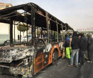 Iranians inspect the wreckage of a bus that was set ablaze by protesters during a demonstration against a rise in gasoline prices in the central city of Isfahan on November 17, 2019. - President Hassan Rouhani warned that riot-hit Iran could not allow 'insecurity' after two days of unrest killed two people and saw authorities arrest dozens and restrict internet access. Rouhani defended the controversial petrol price hike that triggered the protests -- a project which the government says will finance social welfare spending amid a sharp economic downturn (Photo by - / AFP)
