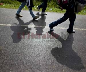 Migrantes hondureños caminan luego de ser deportados desde México. (Foto: Archivo AP)