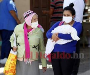 Las nuevas madres se protegen con mascarillas mientras sostienen a los nuevos hondureños.