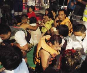 Turistas rescatados de un barco que se hundió se reúnen en un muelle en la isla de Phuket, al sur de Tailandia. Foto AP