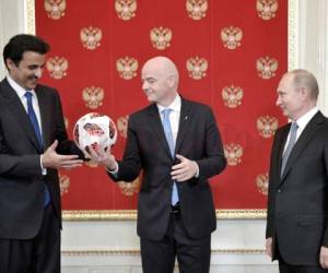 El presidente de la FIFA, Gianni Infantino, pasando la bola de Rusia a Qatar. Foto: Agencia AP.