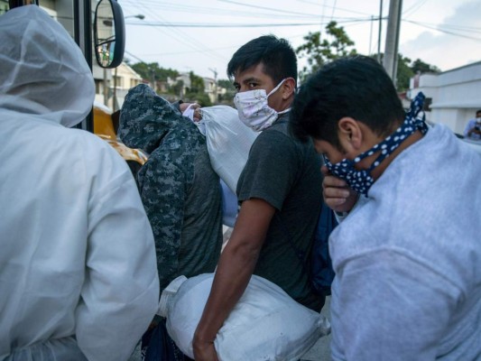 Guatemaltecos deportados por Estados Unidos, usando mascarillas para prevenir el coronavirus, abordan un autobús tras llegar al Aeropuerto La Aurora, en Ciudad de Guatemala, el 9 de junio de 2020. (AP Foto/Moises Castillo).