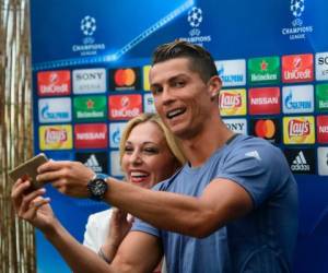 Real Madrid's Portuguese forward Cristiano Ronaldo (R) takes a selfie with a journalist in the mixed zone at Valdebebas Sport City in Madrid on May 30, 2017 at the Media Day event prior to the UEFA Champions League football match final Juventus vs Real Madrid. / AFP PHOTO / PIERRE-PHILIPPE MARCOU