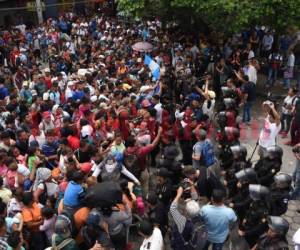 Varias horas permanecieron los hondureños esperando a que las autoridades mexicanas los dejarán ingresar. Foto AFP