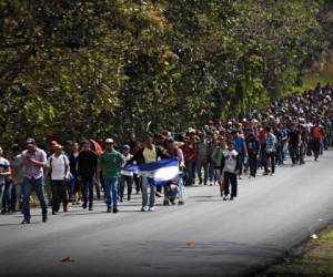 Los migrantes hondureños caminan con una bandera hondureña cerca de Esquipulas, departamento de Chiquimula, Guatemala. Foto: Agencia AFP.