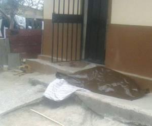 El cadaver del infortunado joven quedó en la acera de su casa junto a su perro, foto: Estalin Irías/ El Heraldo.
