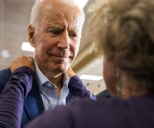 El exvicepresidente y aspirante a la candidatura demócrata para el 2020, Joe Biden, recibe un abrazo de un miembro de la audiencia durante un evento de campaña el 3 de julio de 2019 en Waterloo, Iowa.