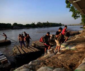 Esta fotografía de archivo del 18 de junio de 2019 muestra a migrantes guatemaltecos desembarcando de una balsa en Ciudad Hidalgo, México, luego de cruzar un río fronterizo con Guatemala.