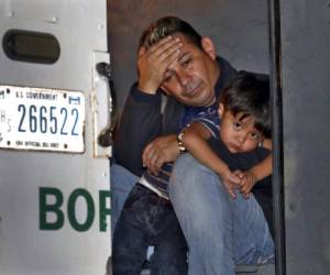 Un padre y su hijo de 3 años se asoman a la puerta de un vehículo de la Patrulla Fronteriza en el que están detenidos en San Luis, Arizona. Foto: AP.
