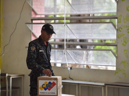 Un policía emite su voto en un colegio electoral en Caracas durante las elecciones del consejo municipal de Venezuela.