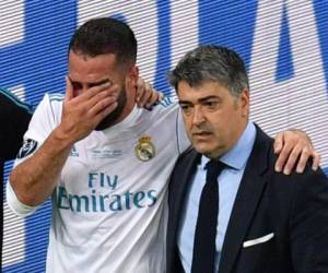 El defensa español del Real Madrid Dani Carvajal (L) es escoltado fuera del terreno de juego tras sufrir una lesión durante el último partido de fútbol de la Liga de Campeones de la UEFA entre el Liverpool y el Real Madrid. Foto AFP