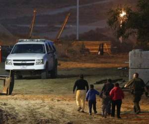 Unos migrantes son escoltados por agentes de la Patrulla Fronteriza de Estados Unidos luego de ser detenidos tras cruzar la frontera con México desde Tijuana. (Foto: AP)