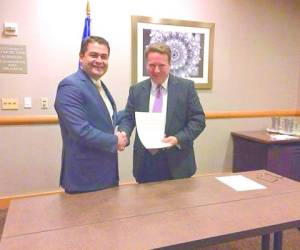 El presidente Hernández al firmar el acuerdo con el representante de ETS.