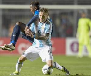 En esta imagen Romell Quioto pelea el balón con el argentino Lucas Bilglia.