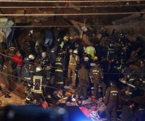 Imagen publicada por Aton Chile que muestra a los bomberos que trabajan en el sitio donde se derrumbó una casa tras un derrumbe en una colina en Valparaíso, Chile, el 13 de agosto de 2019. Agencia AFP.