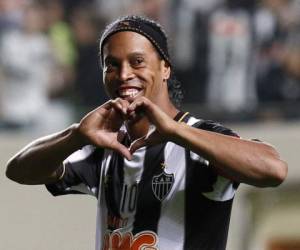 FILE - In this Nov. 28, 2005 file photo, Brazilian soccer player Ronaldinho kisses his trophy after winning the Golden Ball award of the European player of the year, in Paris, France. The brother and agent of 2005 Ballon d'Or winner Ronaldinho says on Tuesday, Jan. 16, 2018, the former Brazil and Barcelona playmaker has retired from football. (AP Photo/Christophe Ena, File)