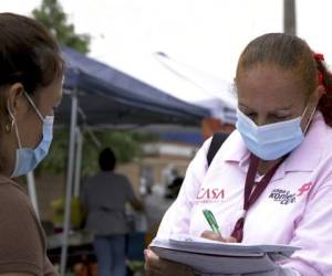 Una promotora de salud de CASA, un grupo hispano de apoyo, trata de registrar a hispanos como voluntarios para pruebas de una potencial vacuna de covid-19. Foto: AP