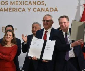 La viceprimera ministra canadiense Chrystia Freeland, el representante comercial de Estados Unidos Robert Lighthizer y el negociador mexicano Jesús Seade muestran documentos después de firmar un acuerdo junto a AMLO. Foto AFP