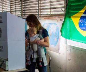 Una brasileña con su bebé, vota en una mesa electoral durante la segunda vuelta de las elecciones presidenciales, en Río de Janeiro, Brasil, el 28 de octubre de 2018.