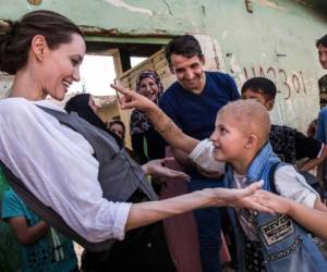 Angelina Jolie junto a un niño víctima de los conflictos armados en IRrak. (AFP)