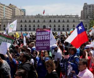 Manifestantes caminan frente al palacio presidencial en Santiago de Chile, el miércoles 30 de octubre de 2019.