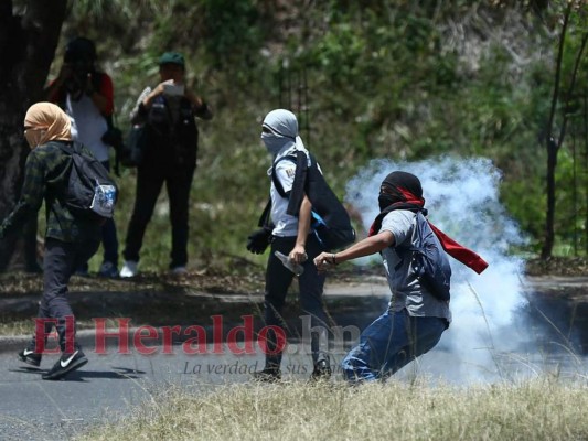 Estudiantes del Instituto Central quemando llantas y bloqueando la entrada de acceso al colegio.