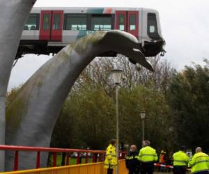 La parte frontal del metro permaneció sostenida por la escultura a una altura de 10 metros, encima del agua. Insólitamente, la escultura se llama 'Salvado por la cola de la ballena'. AP.