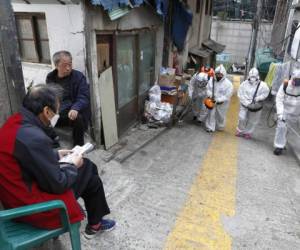Trabajadores rocÃ­an desinfectante como medida de precauciÃ³n contra el nuevo coronavirus en SeÃºl, Corea del Sur. (Park Min-suck/Newsis via AP)