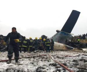 Socorristas efectúan sus labores entre los restos de un avión procedente de Bangladesh que se estrelló en el aeropuerto de Katmandú, en Nepal, el lunes 12 de marzo de 2018. Las autoridades nepalíes confirmaron el martes 13 de marzo que 49 personas murieron.