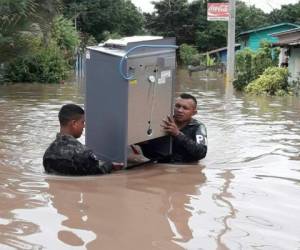 Agentes de la Policía Militar atravesando 'laguna' cargando estufa.