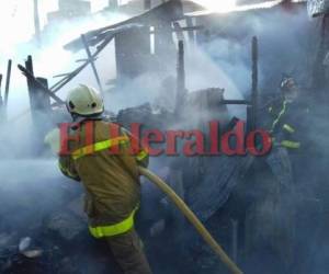 Personal de Cuerpo de Bomberos trata de sofocar las llamas en los puestos del mercado donde este domingo se desató un nuevo incendio. Foto Marvin Salgado/EL HERALDO