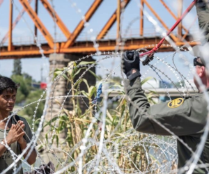 La patrulla fronteriza de Estados Unidos intenta cortar el alambre concertina después de cruzar el Río Grande hacia Eagle Pass, Texas.
