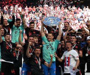 Los jugadores del Bayern de Múnich celebran con el trofeo después del partido de fútbol de la Bundesliga de la primera división alemana entre el FC Colonia y el FC Bayern de Múnich en Colonia, Alemania occidental.