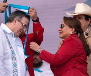 Momento en que la presidenta Castro le ponía la banda del honor al excanciller.