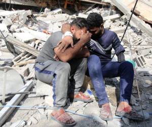 Los palestinos lloran mientras se sientan sobre los escombros de un edificio en el campo de refugiados de Shati en la ciudad de Gaza el 6 de noviembre de 2023, en medio de las batallas en curso entre Israel y el movimiento palestino Hamás.