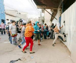 Un grupo de vendedores ambulantes trata de ingresar a la fuerza a las instalaciones de la antigua Penitenciaría Central (PC), donde la Policía Municipal mantenía detenido a uno de los suyos tras el zafarrancho, foto: Jimmy Argueta / EL HERALDO.