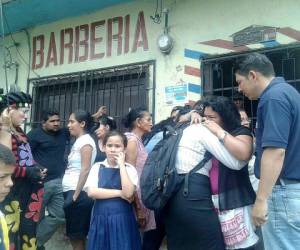 Familiares lloran frente a la barbería donde ocurrió el crimen.