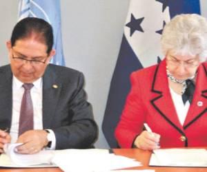 El ministro Jorge Ramón Hernández y la comisionada adjunta Flavia Pansieri en la firma del acuerdo sede.