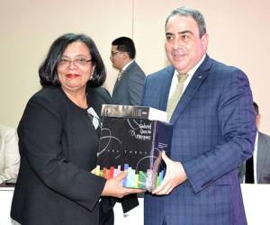 Julieta Castellanos recibe el lote de libros de manos del embajador Roberto Ochoa Madrid.