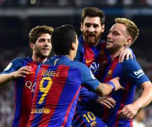 Barcelona's Croatian midfielder Ivan Rakitic (R) celebrates a goal with Barcelona's Argentinian forward Lionel Messi (2R) and Barcelona's Uruguayan forward Luis Suarez (2L) during the Spanish league football match Real Madrid CF vs FC Barcelona at the Santiago Bernabeu stadium in Madrid on April 23, 2017. / AFP PHOTO / GERARD JULIEN