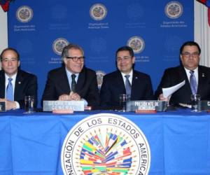 El secretario de la OEA, Luis Almagro, y el presidente Juan Orlando Hernández, al centro, durante la firma del acuerdo en enero.