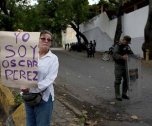 Una mujer que dijo ser una seguidora, el oficial de policía rebelde Oscar Pérez tiene un cartel que dice en español 'Soy Oscar Pérez' en un puesto de control cerca de la morgue donde se encuentra su cuerpo, en Caracas, Venezuela. Agencia AP