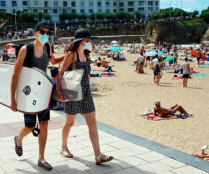 Personas usan cubrebocas mientras disfrutan de la playa en Biarritz, al suroeste de Francia. Foto AP.